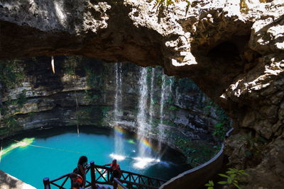 People on rock formation in cave