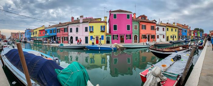 Boats moored at harbor by buildings in city