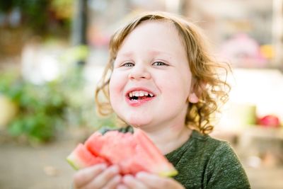 Portrait of cute boy eating watermelon outdoors