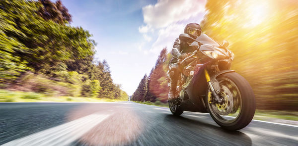 Blurred motion of person riding motorcycle on road