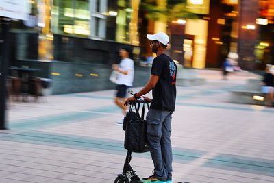 Full length side view of man walking on street in city