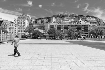 Woman standing on city street against sky