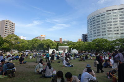 Group of people in front of buildings against sky