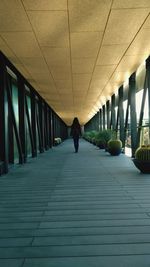 Rear view of man and woman walking in corridor