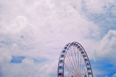 Low angle view of ferris wheel against cloudy sky