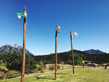 Street light by mountains against clear blue sky