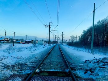 Railroad tracks against sky during winter