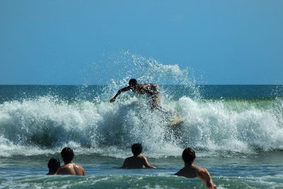 People enjoying in sea against clear sky