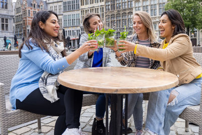 Portrait of smiling friends sitting at restaurant