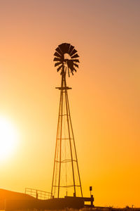 Low angle view of silhouette ferris wheel against sky during sunset