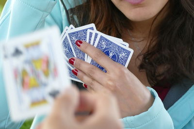 Midsection of woman playing cards