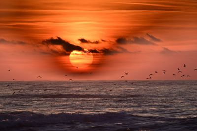 Scenic view of sea against orange sky