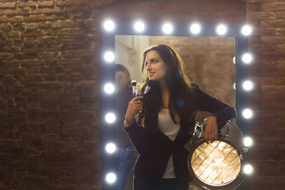 Woman standing against illuminated lights