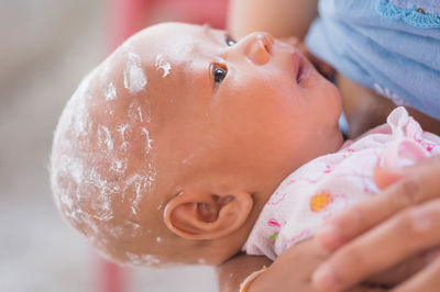 Midsection of woman feeding toddler son at home