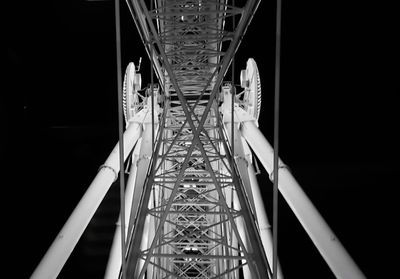 Low angle view of illuminated ferris wheel against black background