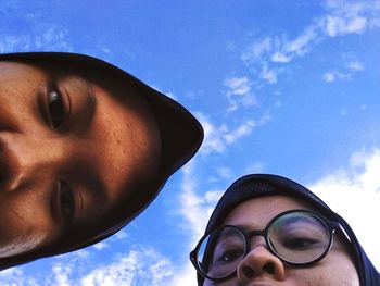 Low angle portrait of man wearing sunglasses against sky