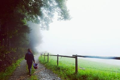 Rear view of woman walking on footpath
