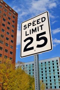 Low angle view of road sign against sky