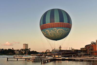 Hot air balloon flying over water against sky