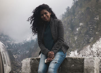 Portrait of smiling young woman standing outdoors