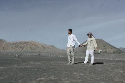 Men standing on desert against sky