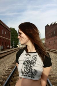 Portrait of young woman standing against buildings