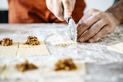 Cropped hands of male chef preparing food on table