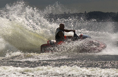 Man riding jet boat in sea during sunny day