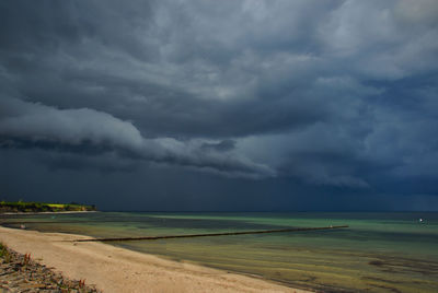 Scenic view of sea against storm clouds