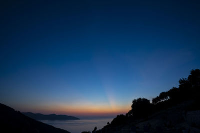Scenic view of silhouette mountains against sky at sunset