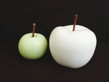 Close-up of apple on table against black background