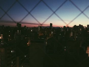 Illuminated cityscape against sky at night