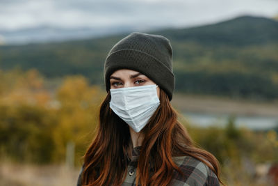 Portrait of young woman wearing hat outdoors