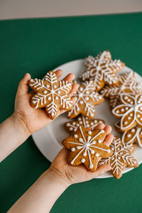 Ginger christmas cookies in children's hands on the background of the christmas tree.