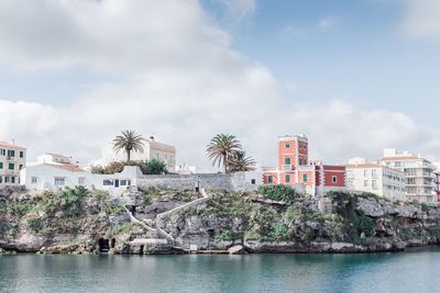 Palm trees by buildings against sky