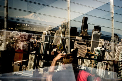 Man and modern buildings in city against sky