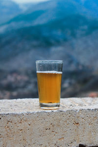 Close-up of beer glass on retaining wall