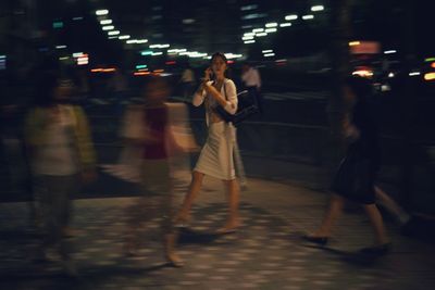 Blurred motion of woman in city at night