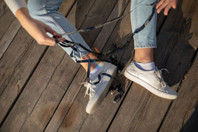 Low section of woman with tape tangled sitting on wood