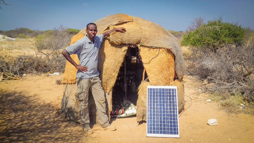 A young man standing next to a nomad house near hiiraan african villages