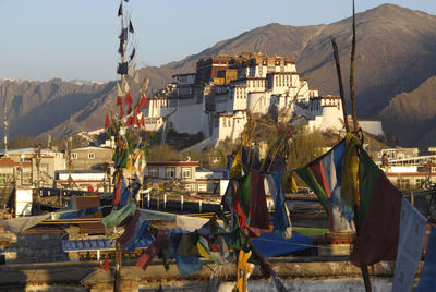 Clothes drying on clothesline in city against clear sky