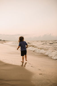 Boy on beach at sunrise