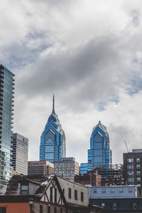 Buildings in city against cloudy sky