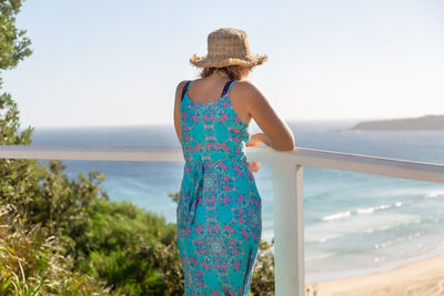 Rear view of woman looking at sea against sky