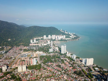 High angle view of city by sea against sky