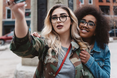 Friends taking selfie while standing in city