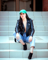 Portrait of young woman sitting on staircase