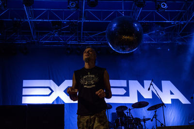 Full length of man standing on illuminated stage