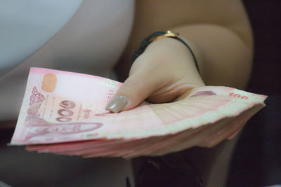 Cropped hand of woman holding paper currencies