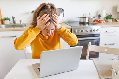 Young woman using laptop at home